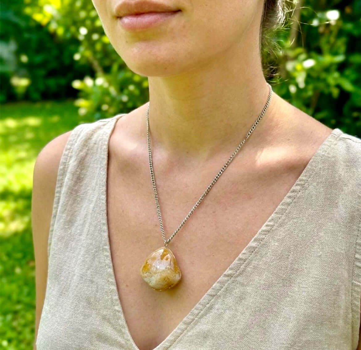 Collana Artigianale con Pietra Minerale Naturale dei Fiumi della Valsesia indossata in un ambiente verde.