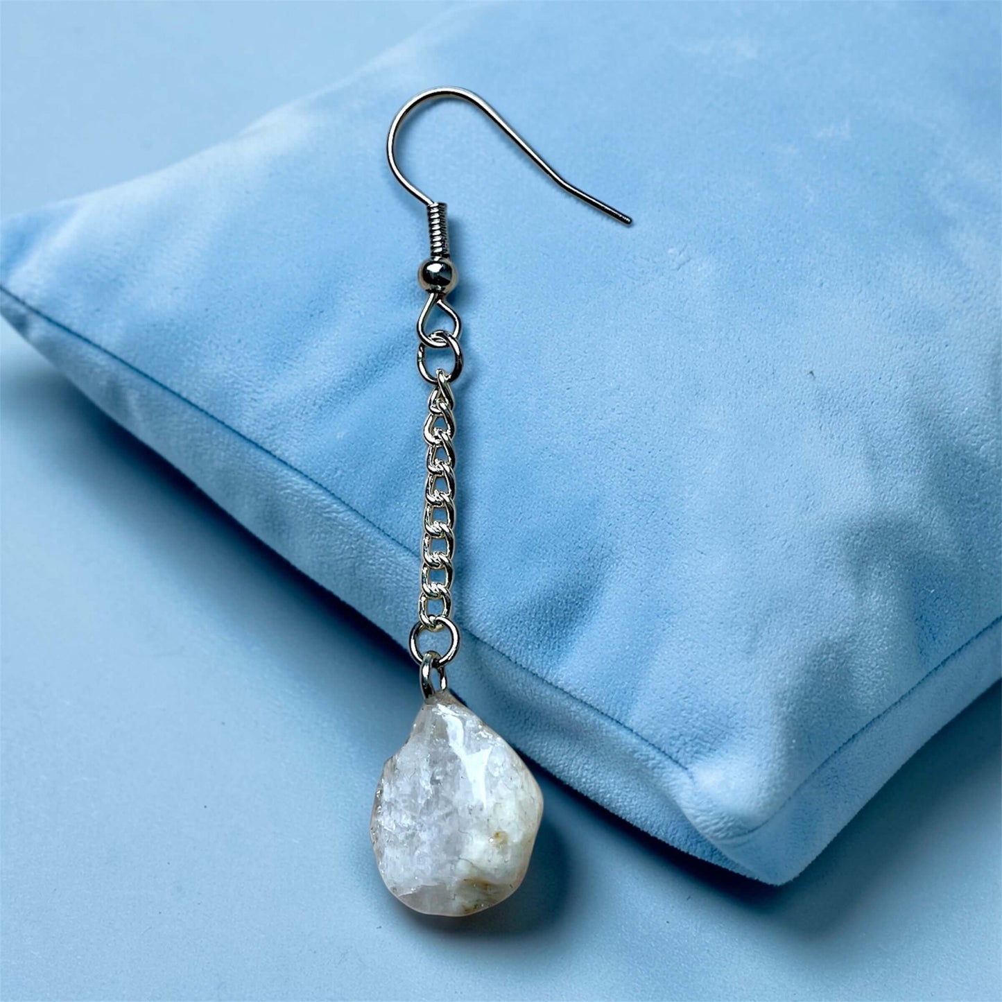 Orecchini Pendenti Artigianali con Pietre Naturali della Valsesia, in pietra focaia bianca su cuscino blu.