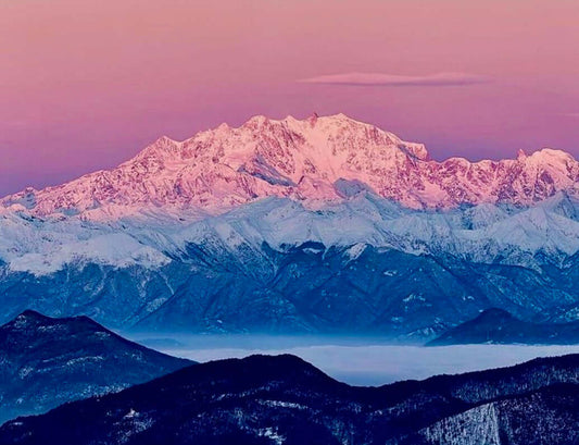 WHO WE ARE: Stunning view of snow-covered mountains during sunset.