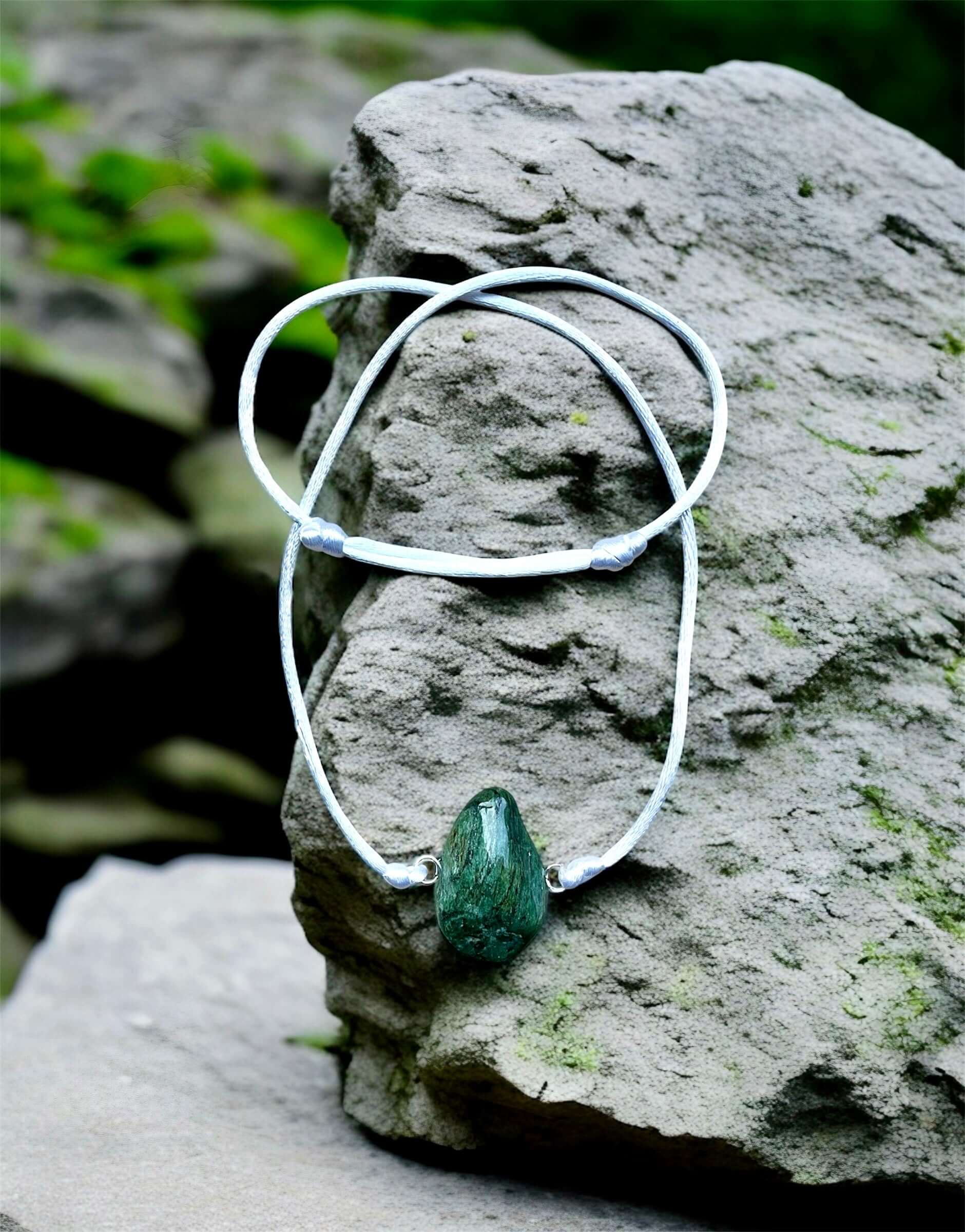 Collier Artigianale con Pietra Naturale dei Fiumi della Valsesia su una pietra naturale nel bosco.