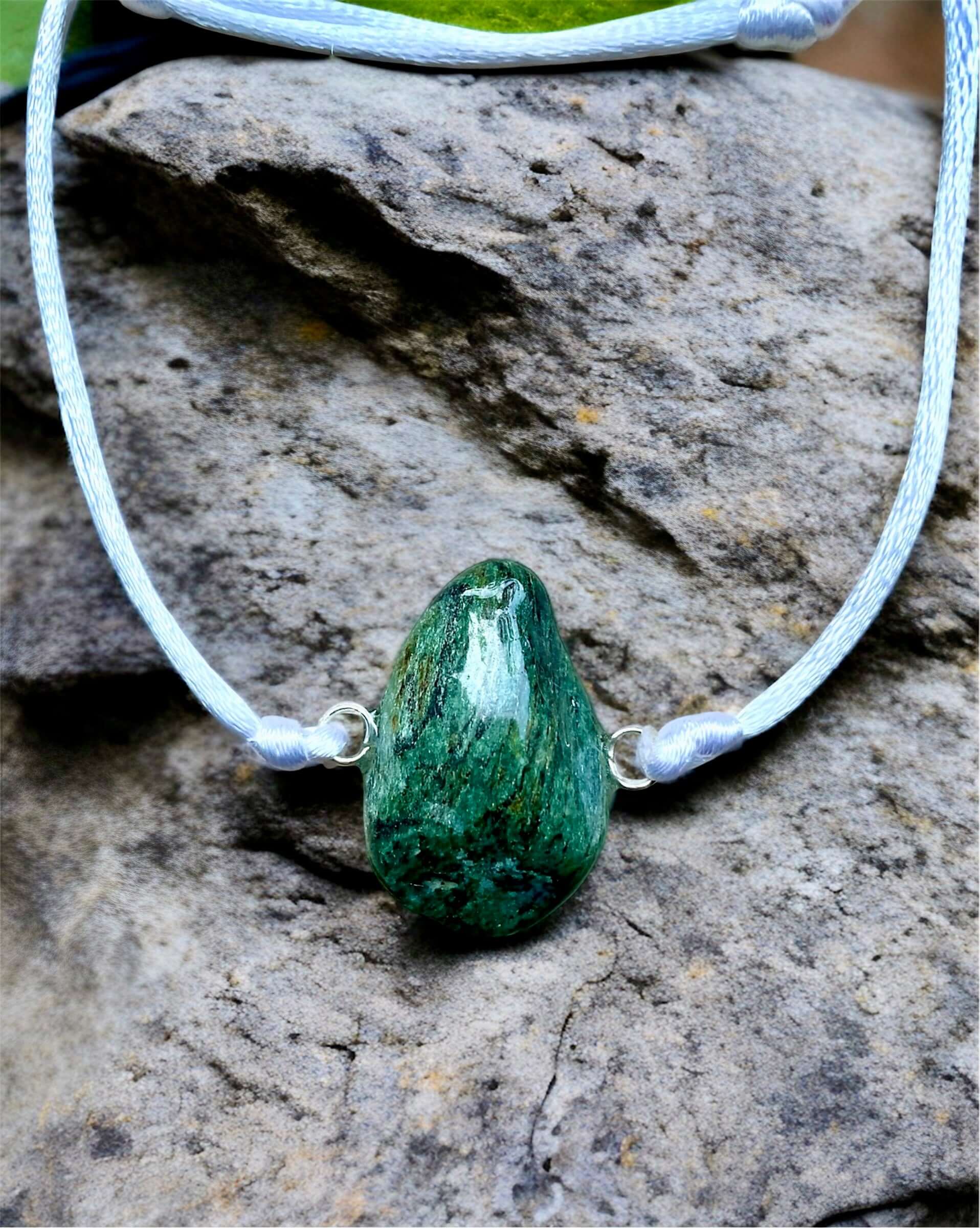 Collier Artigianale con Pietra Naturale dei Fiumi della Valsesia su una pietra naturale nel bosco.