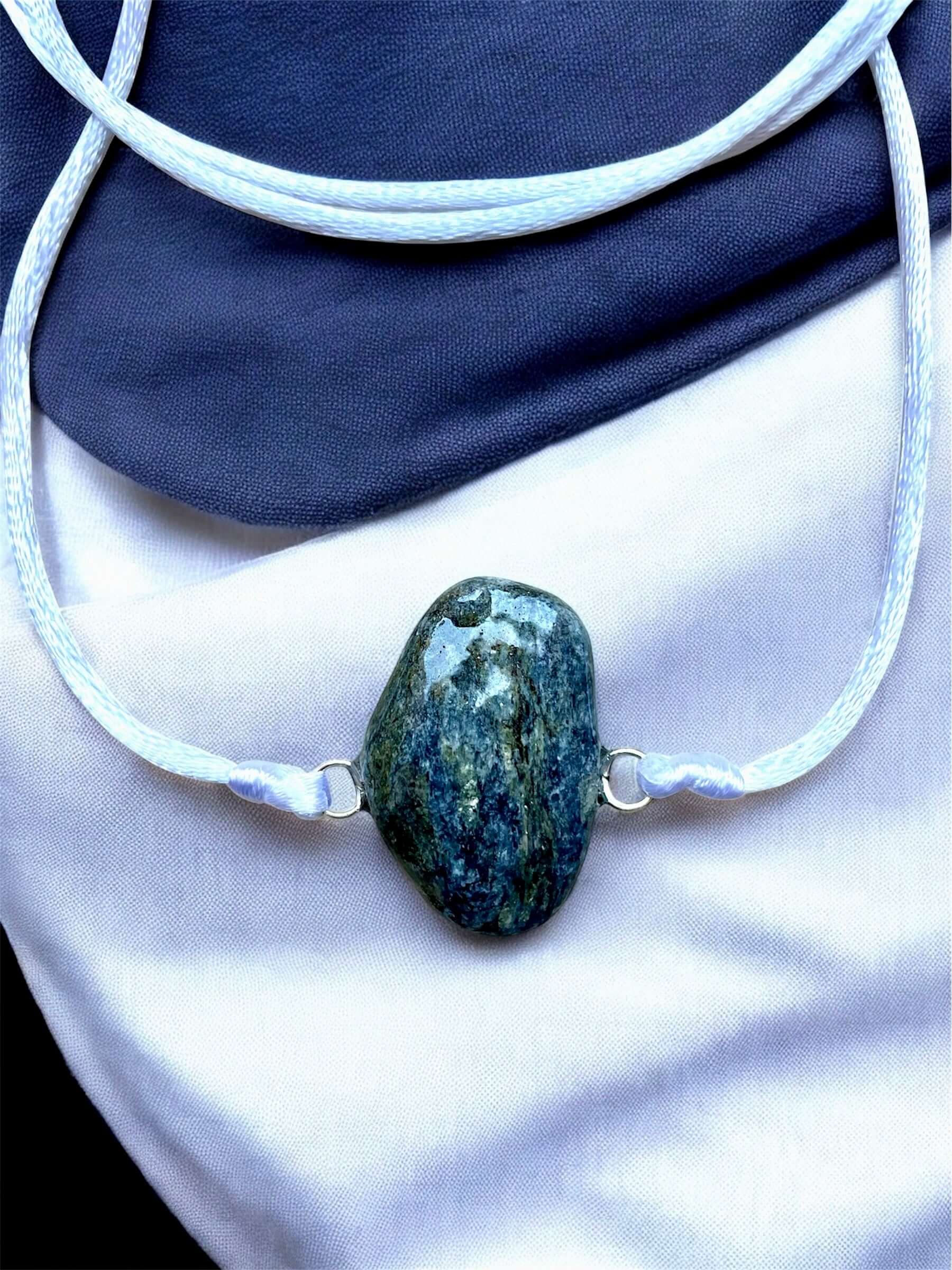 Collier Artigianale con Gemma Naturale dei Fiumi della Valsesia con pietra grezza su sfondo elegante.