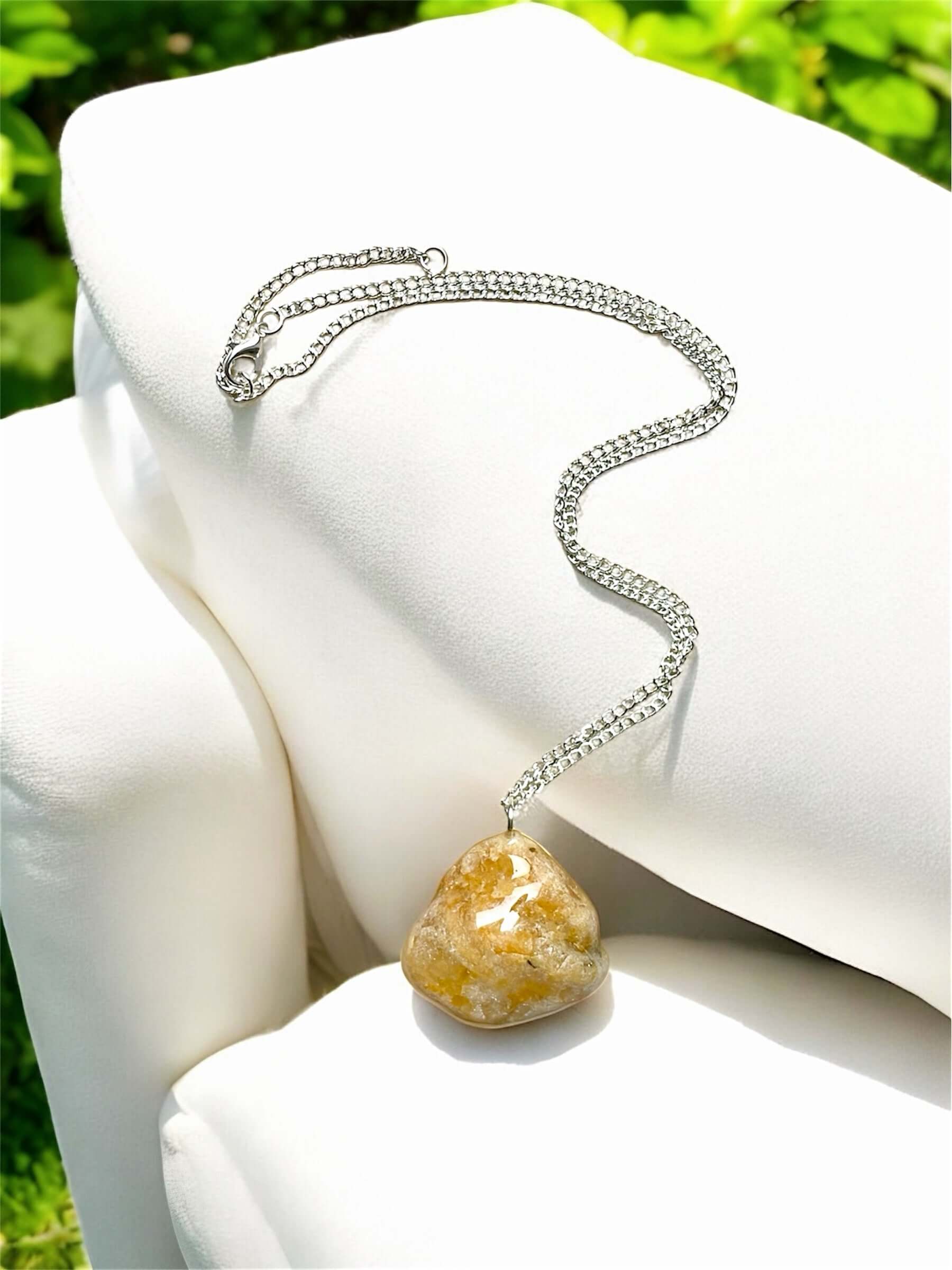 Collana Artigianale con Pietra Minerale Naturale dei Fiumi della Valsesia appoggiata su un cuscino elegante.