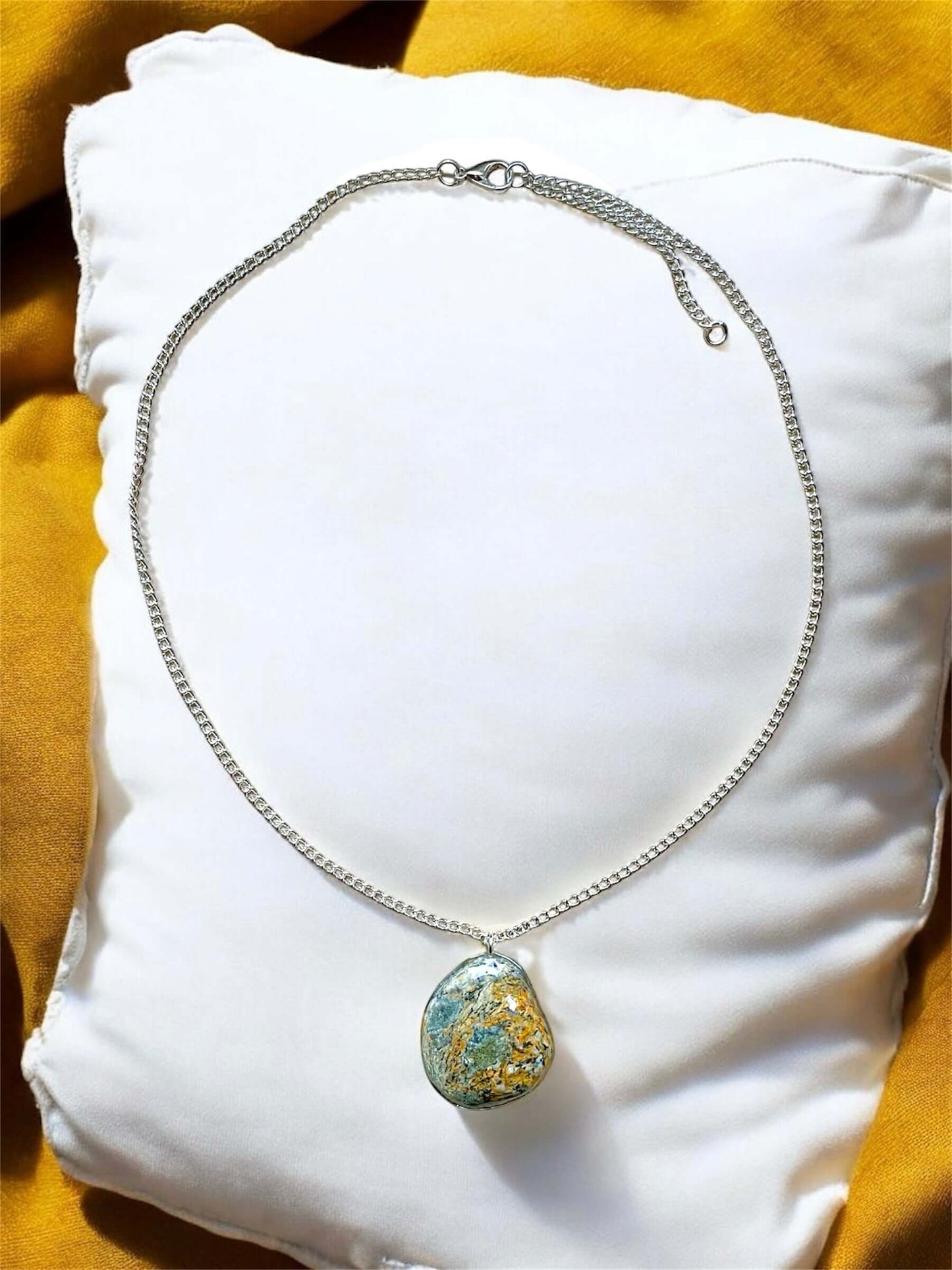 Collana Artigianale con Pietra Minerale Naturale dei Fiumi della Valsesia su un cuscino, con etichetta Crepuscolo.