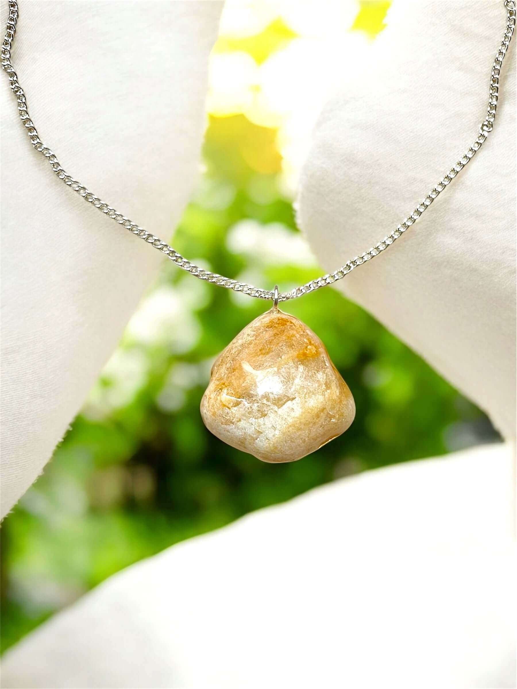 Collana Artigianale con Pietra Minerale Naturale dei Fiumi della Valsesia appoggiata su un cuscino elegante.