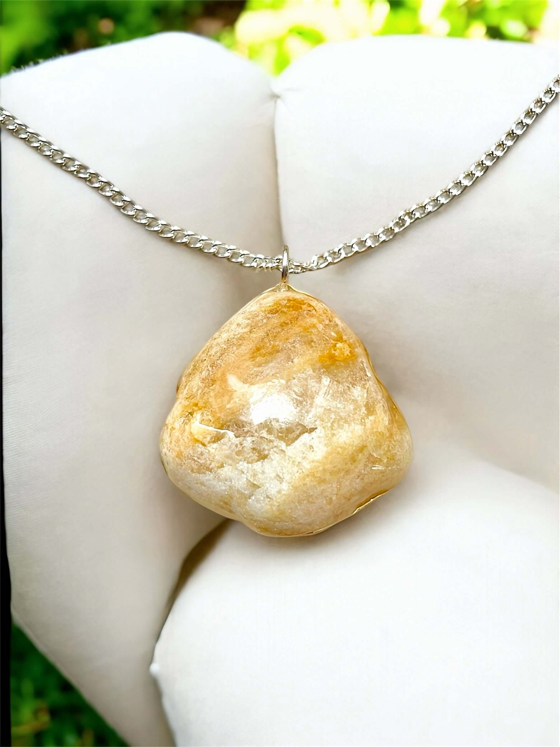 Collana Artigianale con Pietra Minerale Naturale dei Fiumi della Valsesia appoggiata su un cuscino elegante.