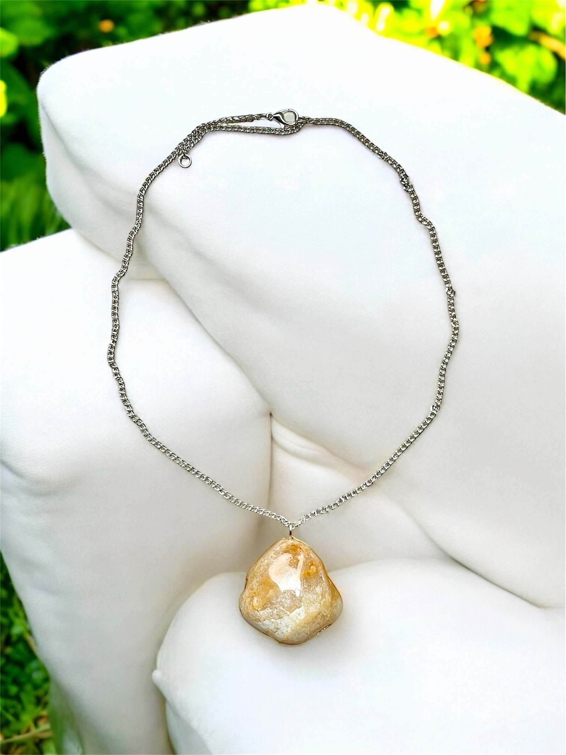 Collana Artigianale con Pietra Minerale Naturale dei Fiumi della Valsesia appoggiata su un cuscino elegante.