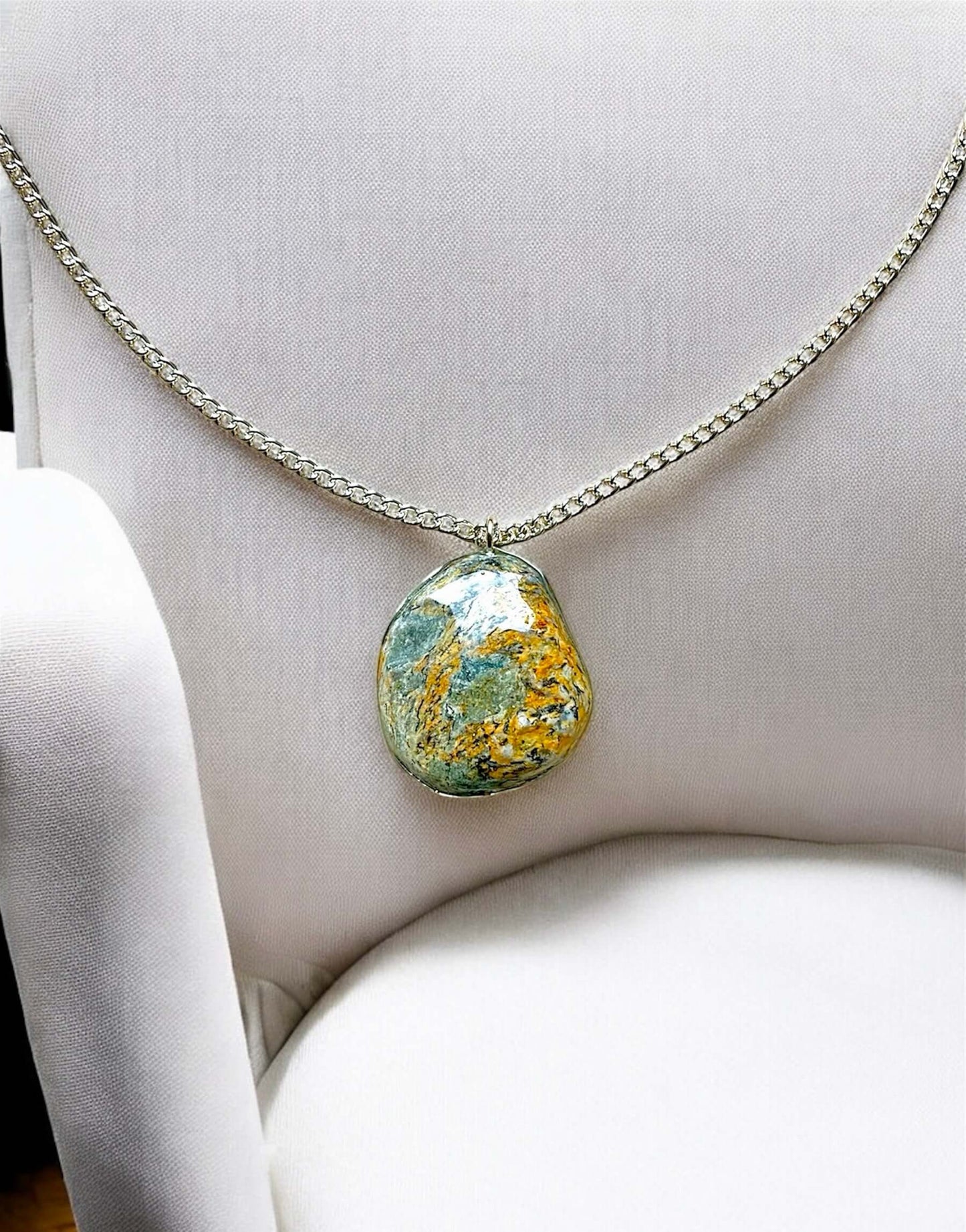 Collana Artigianale con Pietra Minerale Naturale dei Fiumi della Valsesia su un cuscino, con etichetta Crepuscolo.