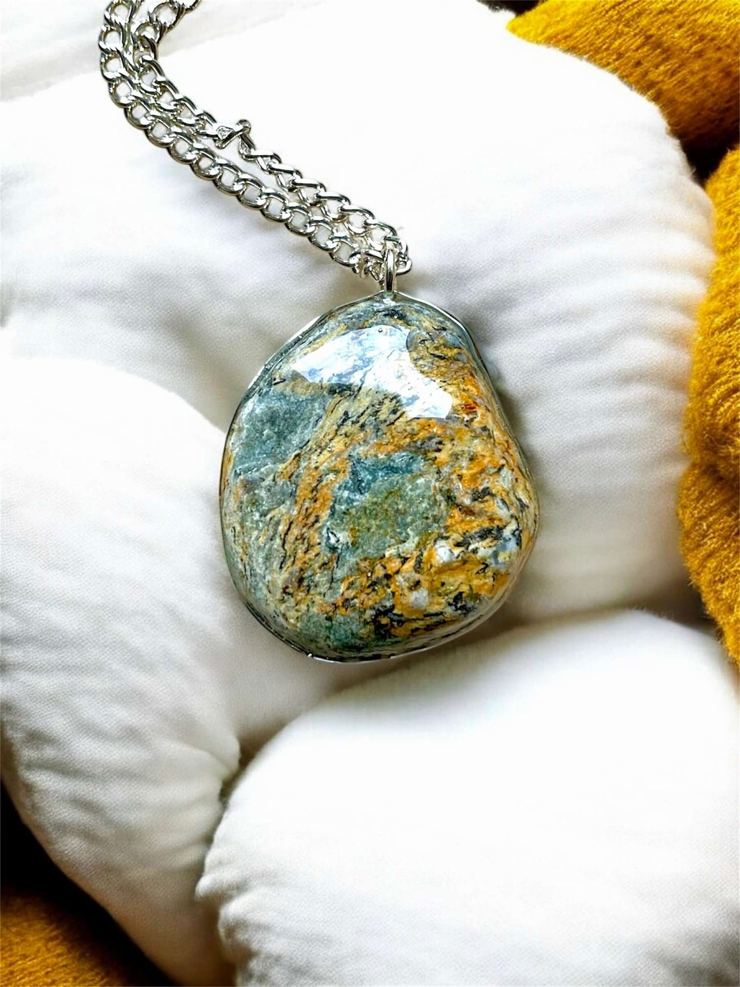 Collana Artigianale con Pietra Minerale Naturale dei Fiumi della Valsesia su un cuscino, con etichetta Crepuscolo.
