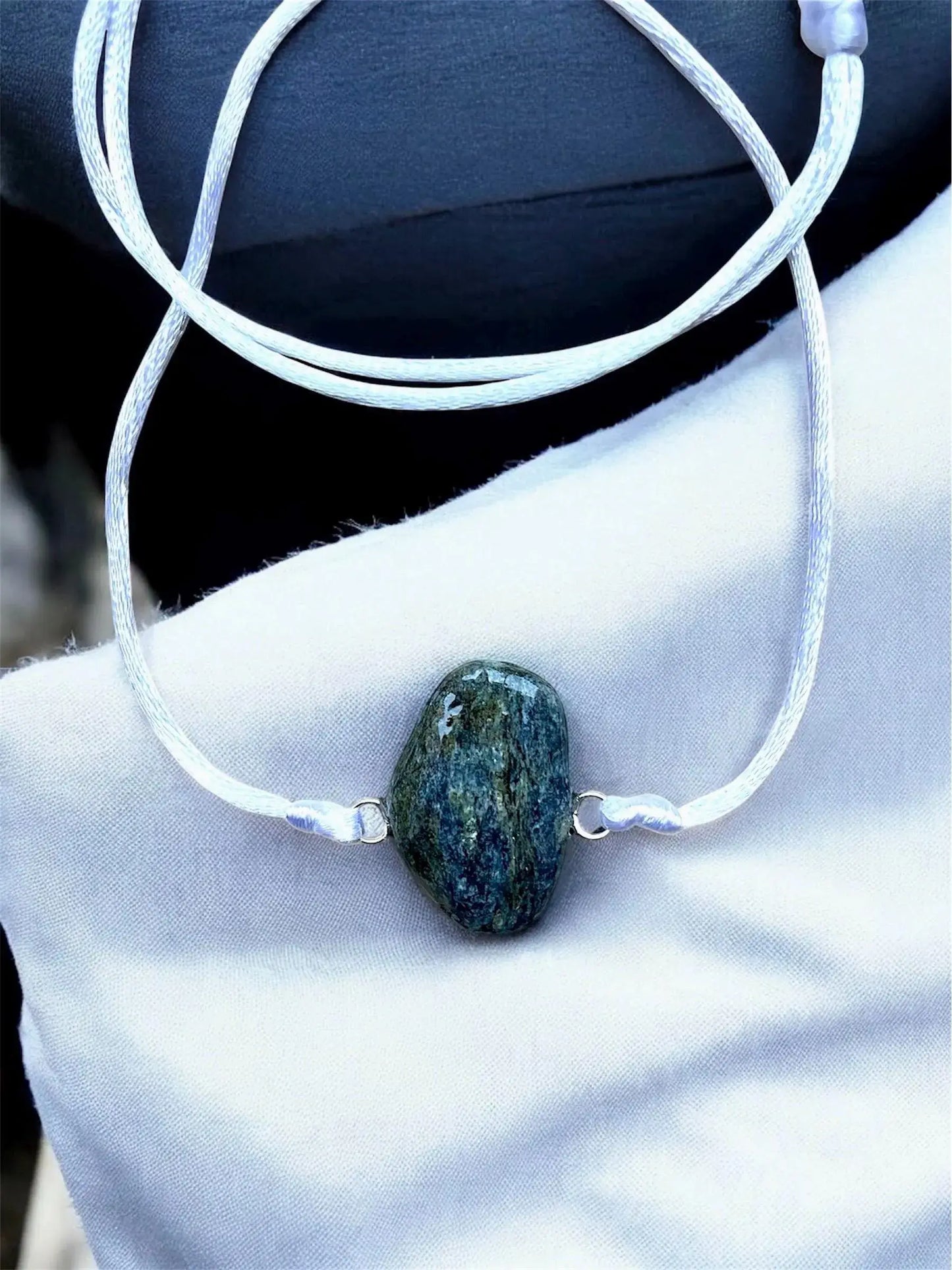 Collier Artigianale con Gemma Naturale dei Fiumi della Valsesia con pietra grezza su sfondo elegante.