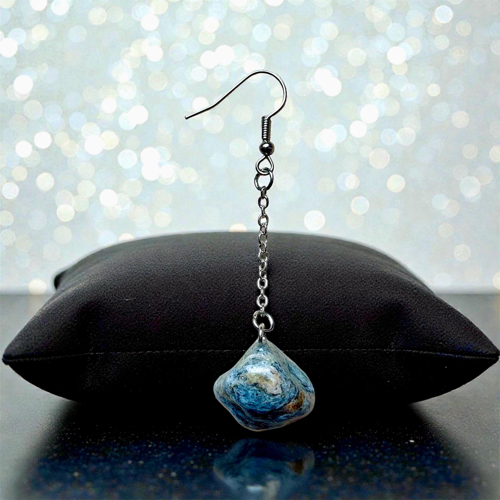 Orecchini Pendenti Artigianali con Pietre Naturali della Valsesia, lucente pietra blu su cuscino nero.