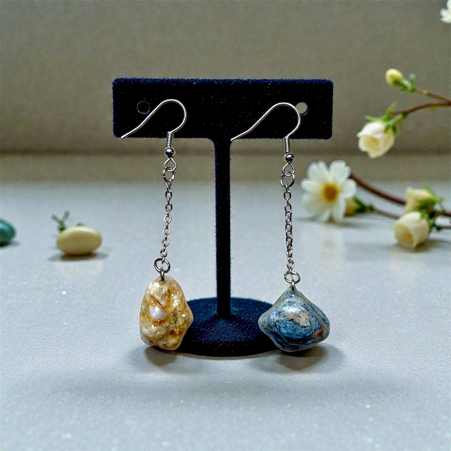 Orecchini Pendenti Artigianali con Pietre Naturali della Valsesia in avorio dorato e blu minerale su portagioie.